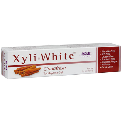 Cutie carton albă Now Solutions XyliWhite Cinnafresh cu text mare violet XyliWhite, ilustrație bețișoare scorțișoară, Toothpaste Gel 181g vizibil, bandă laterală roșie cu beneficii Fluoride-Free, SLS-Free, Gluten-Free, Paraben-Free, Reduces Plaque, Whitens, Fresh Taste. Pastă de dinți gel naturală cu 25% xylitol și ulei de scorțișoară pentru curățare profundă și albire naturală. Fără fluor, SLS sau parabeni, reduce placa bacteriană, potrivită pentru dinți sensibili și întreaga familie.