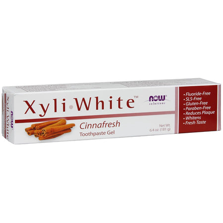 Cutie carton albă Now Solutions XyliWhite Cinnafresh cu text mare violet XyliWhite, ilustrație bețișoare scorțișoară, Toothpaste Gel 181g vizibil, bandă laterală roșie cu beneficii Fluoride-Free, SLS-Free, Gluten-Free, Paraben-Free, Reduces Plaque, Whitens, Fresh Taste. Pastă de dinți gel naturală cu 25% xylitol și ulei de scorțișoară pentru curățare profundă și albire naturală. Fără fluor, SLS sau parabeni, reduce placa bacteriană, potrivită pentru dinți sensibili și întreaga familie.